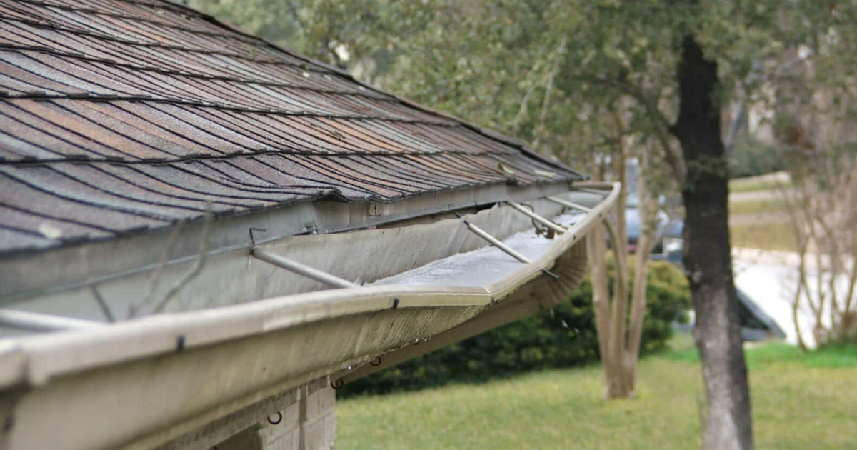 Damaged gutter with visible leaks and corrosion needing repair.